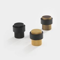 three black and gold knobs on a white background, one is for the camera