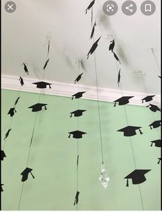 graduation caps and tassels are suspended from the ceiling