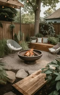 an outdoor fire pit surrounded by chairs and trees