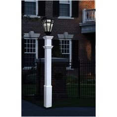 a white lamp post in front of a brick building