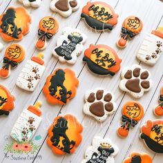 decorated cookies are arranged on a table for the halloween themed party, including jack - o'- lanterns and pumpkins