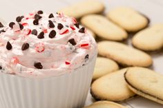 a cupcake with white frosting and chocolate chips on top, surrounded by cookies