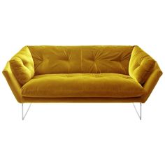 a yellow couch sitting on top of a white floor next to a metal frame chair