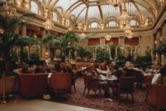 people are sitting at tables in a fancy restaurant