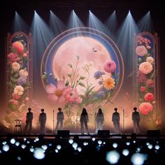 a group of people standing on top of a stage next to each other under spotlights