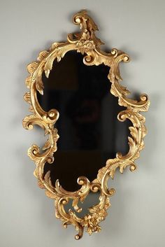 an ornate gold framed mirror hanging on the wall