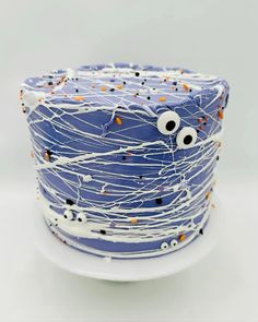 a blue cake decorated with sprinkles and eyes