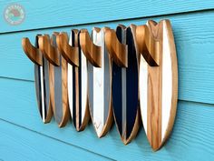 several surfboards mounted to the side of a blue building