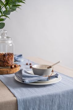 a table topped with plates and bowls filled with food next to a potted plant