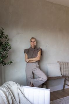 a woman leaning against the wall in her living room