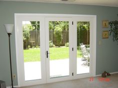 a living room with sliding glass doors leading to a patio and back yard in the background