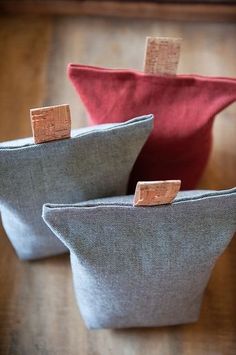 two small gray and red bags sitting on top of a wooden table next to each other