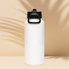 a white water bottle with a black lid on a tan surface, next to a shadow of a palm tree