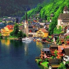 an aerial view of a small town on the edge of a body of water with mountains in the background