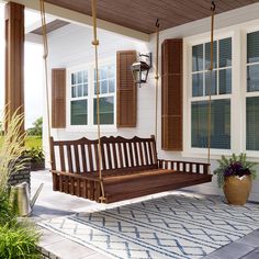 a wooden porch swing sitting on top of a rug