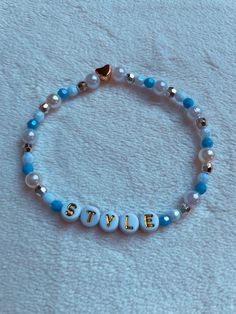 a beaded bracelet with the word style written in gold letters on blue glass beads