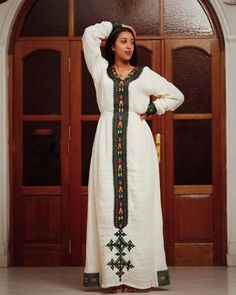 This Habesha Kemis is a true work of art, crafted from handwoven Axum fabric that showcases the rich cultural heritage of Ethiopia. The intricate patterns and vibrant colors of the fabric are a testament to the skill and artistry of the weavers, creating a mesmerizing and eye-catching effect. The dress is expertly crafted with intricate details that highlight the beauty of the wearer, from the flowing sleeves to the elegant neckline. The simple and elegant design of the dress allows the handwove Eritrean Dress, Ethiopian Wedding, Ethiopian Clothing, Habesha Dress, Ethiopian Traditional Dress, Ethiopian Dress, Habesha Kemis, Flowing Sleeves, Traditional Clothes