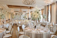 a banquet room set up with tables, chairs and chandeliers