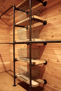 the shelves are made out of metal pipes and wooden planks, with baskets on them