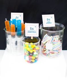 there are several containers with candy in them and labels on the lids for each container