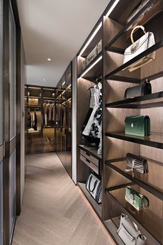 a walk in closet filled with lots of purses and handbags