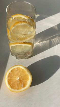 a glass of water with lemon slices next to it