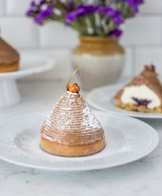 three desserts on white plates with purple flowers in the background