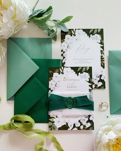 the wedding stationery is green and white, with flowers on each side as well