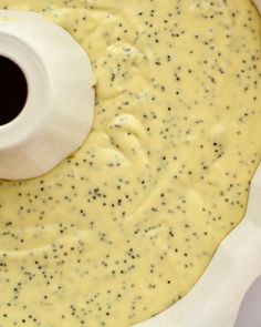 a food processor is making something yellow and black in the batter, with an egg yogurt container next to it