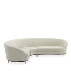 the curved sectional sofa is white and has two legs that are attached to each other