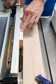 a person using a table saw to cut a piece of wood with a large tool