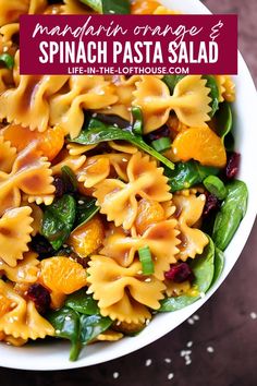 pasta salad with spinach and oranges in a white bowl