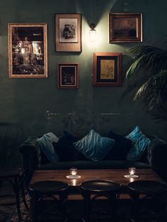 a living room filled with furniture and framed pictures on the wall above it's coffee table