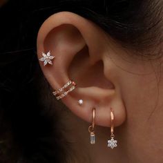 a woman wearing three different types of ear piercings