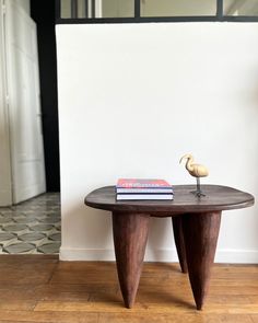 a table with a book on it and a bird figurine sitting on top