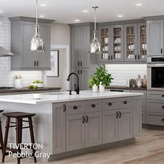 a large kitchen with gray cabinets and white counter tops