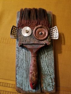 a hair dryer shaped like a face on top of a wooden board with brushes