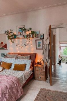 a bed room with a neatly made bed and lots of pictures on the wall above it