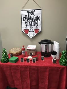 a red table topped with lots of food next to a sign that says hot chocolate station