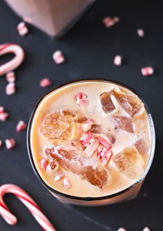 a drink in a glass with candy canes around it