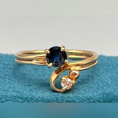 two gold rings with blue and white stones on them sitting on top of a towel