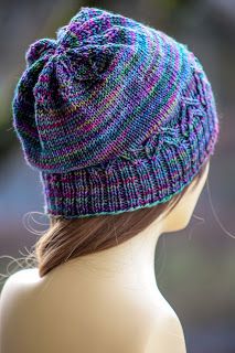 a female mannequin head wearing a multicolored knitted beanie hat