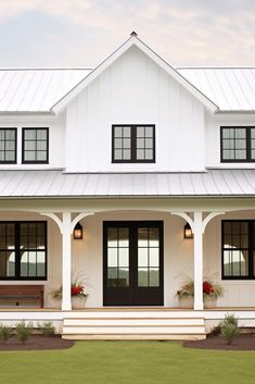 a white house with black shutters and two large windows on the front porch area