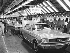 an assembly line with old cars being worked on