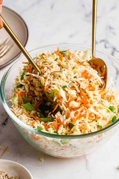 a bowl filled with coleslaw and carrots on top of a marble counter