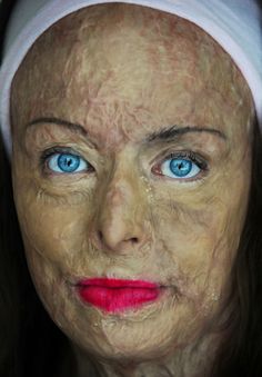 a woman with blue eyes and a white headband on her head is looking at the camera