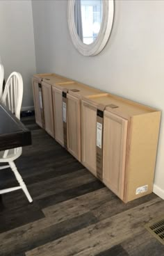 a room that has some cabinets on the floor and a table in front of it