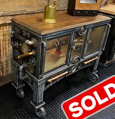 a sold sign sitting on top of a table next to an old fashioned radio cabinet