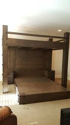 a wooden bed frame in the middle of a living room