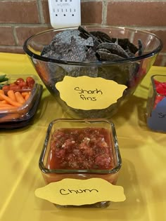 the table is set up with bowls of food and labels for each individual to label